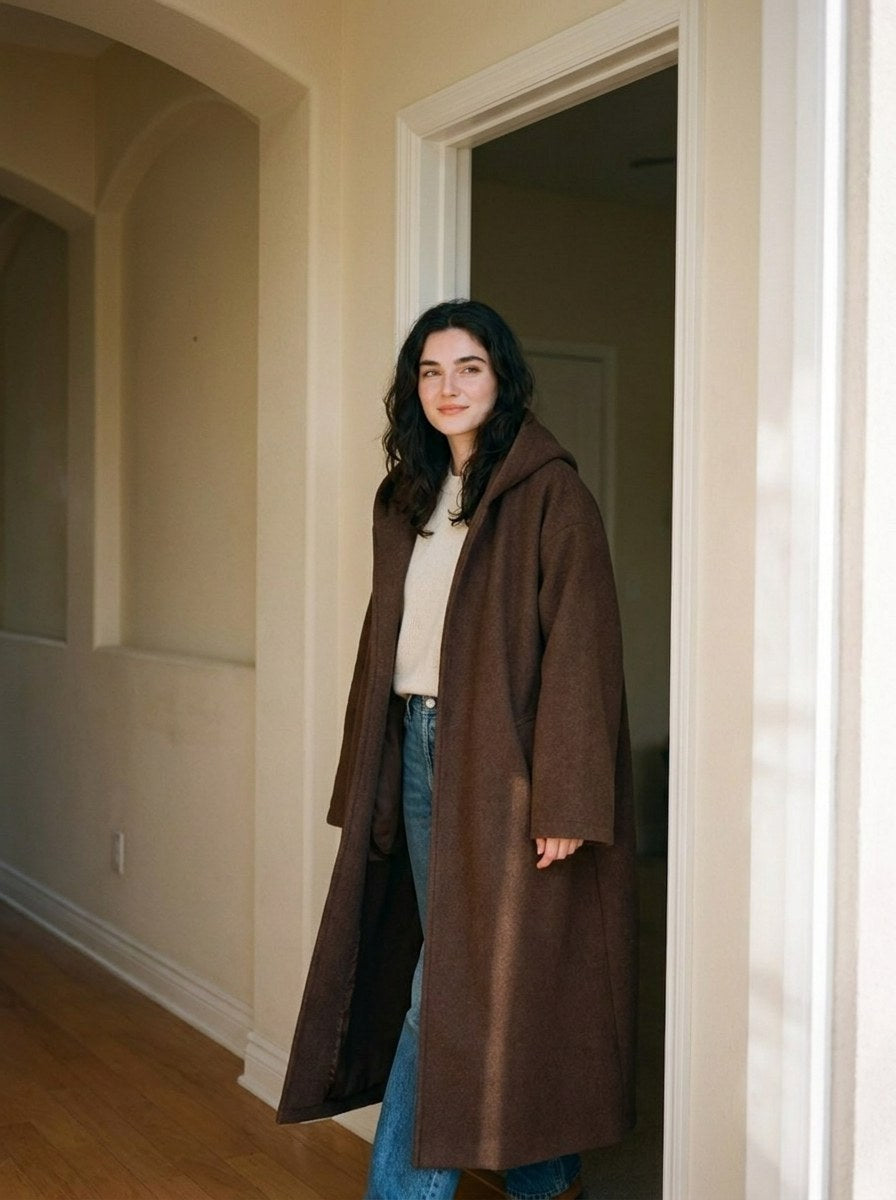 A woman stepping out of a doorway in The Exhale in Terra, worn over the day clothes
